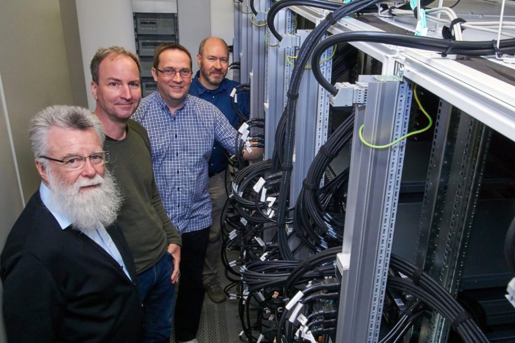 Die Arbeitsgruppe „Computersimulation und Gitterfeldtheorie“ erforscht mit dem Hochleistungsrechner stark wechselwirkende Materie: Prof. Dr. Frithjof Karsch, Markus Klappenbach, Dr. Olaf Kaczmarek, Dr. Christian Schmidt (v.l.). Foto: Universität Bielefeld, H. Sandmeyer