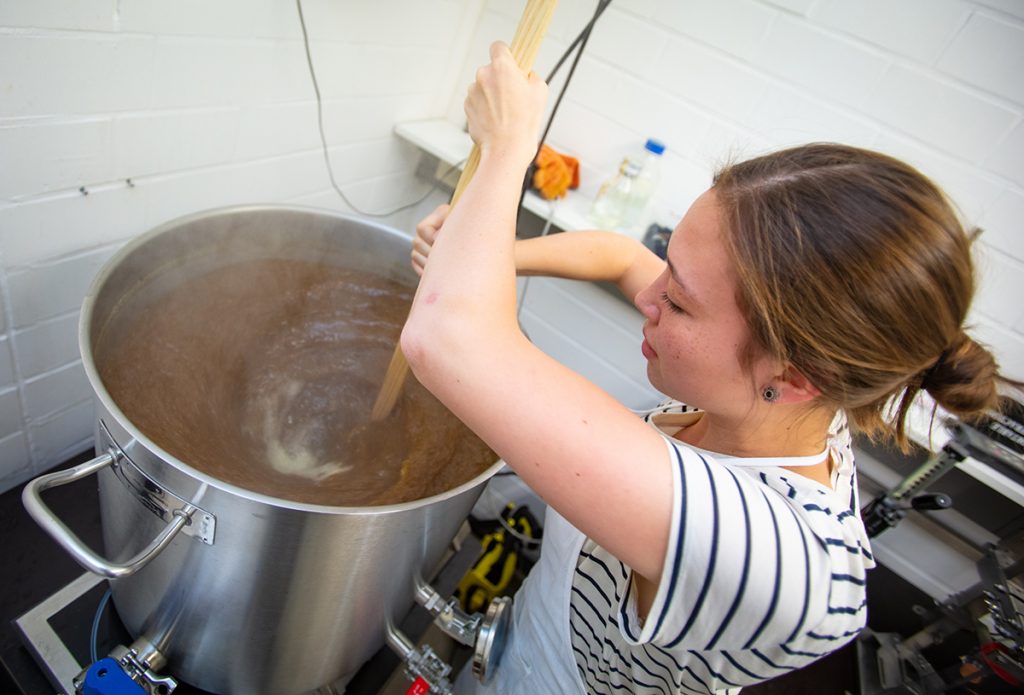 Tulsi Wormuth (22) erzeugt im Kessel einen Strudel, den sogenannten Whirlpool. Foto: Universität Bielefeld / Mike-Dennis Müller