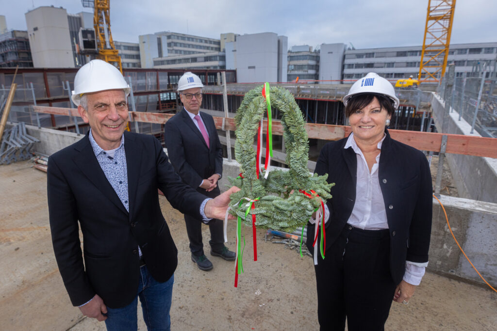 Der Rohbau des Unineubaus ist fertig v.l.): Rektor Prof. Dr.-Ing. Gerhard Sagerer, BLB NRW-Geschäftsführerin Gabriele Willems und BLB NRW-Niederlassungsleiter Wolfgang Feldmann (im Hintergrund). Bild mit kleinem Richtkranz