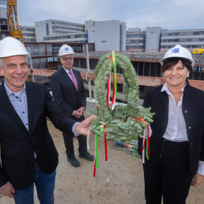 Der Rohbau des Unineubaus ist fertig v.l.): Rektor Prof. Dr.-Ing. Gerhard Sagerer, BLB NRW-Geschäftsführerin Gabriele Willems und BLB NRW-Niederlassungsleiter Wolfgang Feldmann (im Hintergrund). Bild mit kleinem Richtkranz