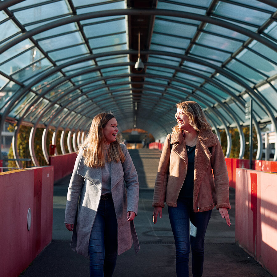 Zwei lachende Studierende auf der Uni-Brücke.