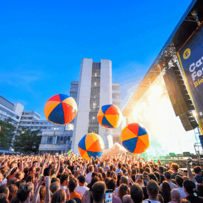 Menschenmenge vor der Hauptbühne mit großen bunten Bällen.